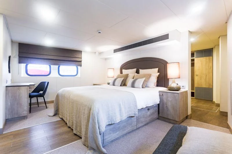 a bedroom with a bed and a desk aboard POWER PLAY Yacht for Sale