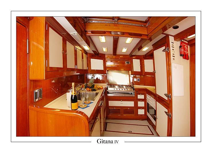 a kitchen with wooden cabinets aboard GITANA IV Yacht for Sale