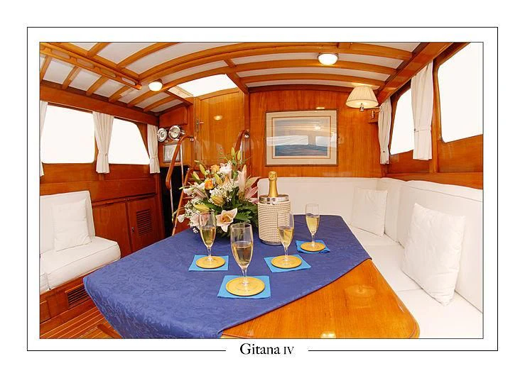 a dining table with wine glasses and flowers on it aboard GITANA IV Yacht for Sale