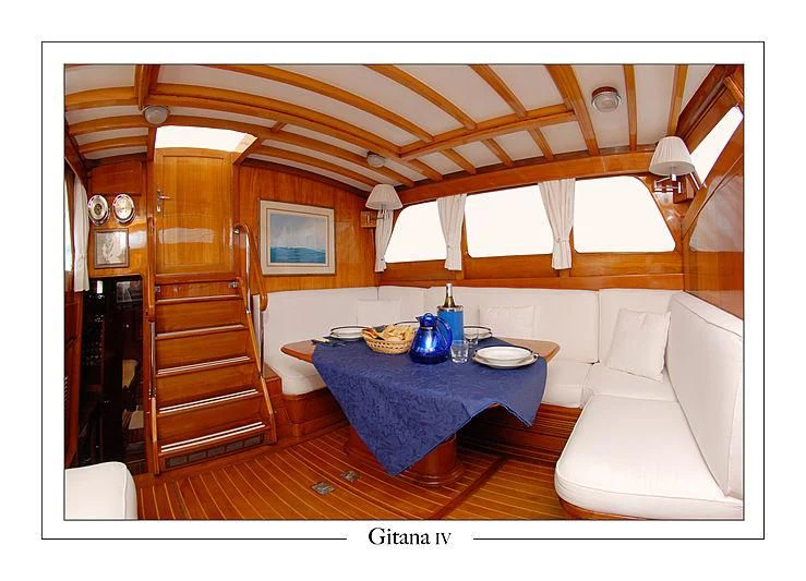 a room with a bed and a table aboard GITANA IV Yacht for Sale
