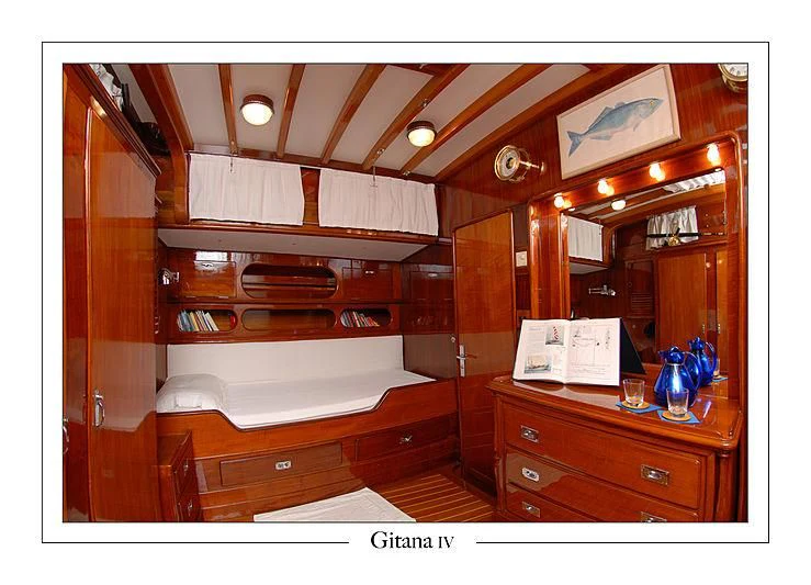 a room with a bed and a mirror aboard GITANA IV Yacht for Sale