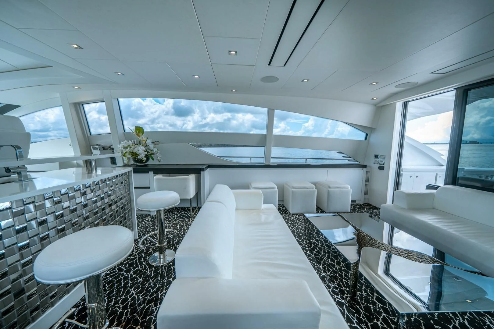 inside of a vehicle with a large white table and chairs aboard HAWK Yacht for Charter