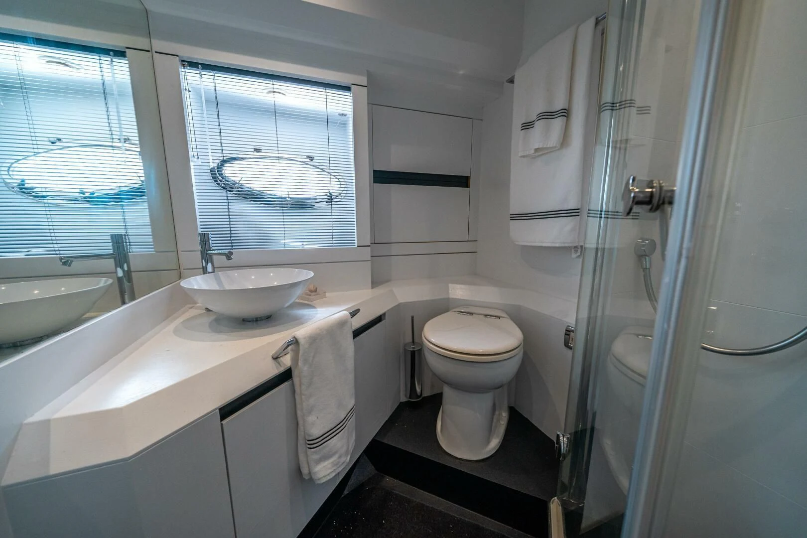 a bathroom with a sink toilet and a window aboard HAWK Yacht for Charter