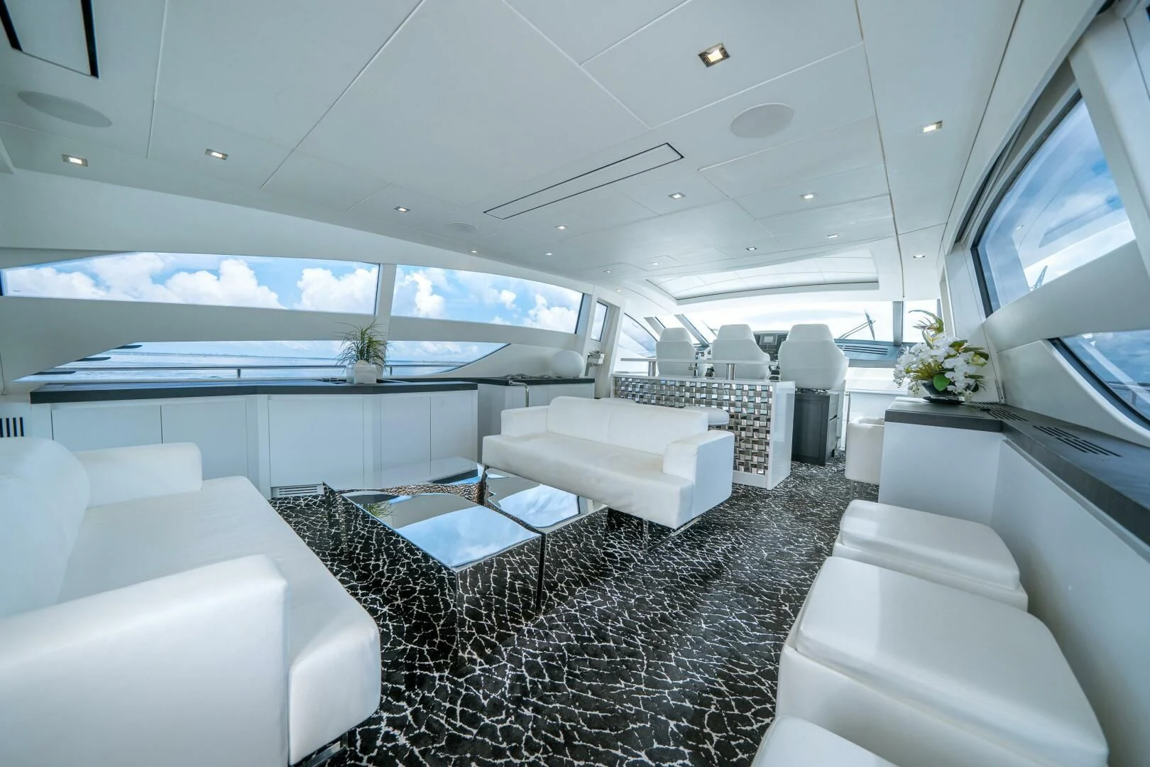 a room with a large window and a table with chairs aboard HAWK Yacht for Charter