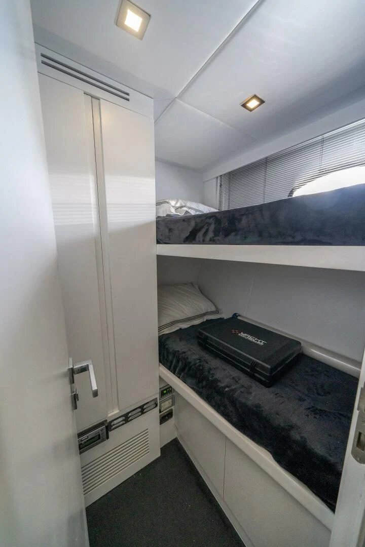 a small room with a bed and a computer aboard HAWK Yacht for Charter