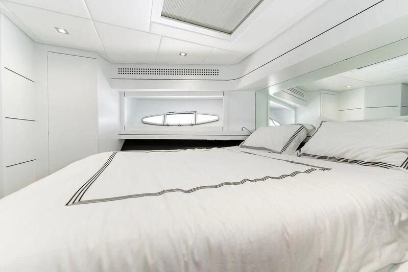 a white bedroom with a bed aboard HAWK Yacht for Charter
