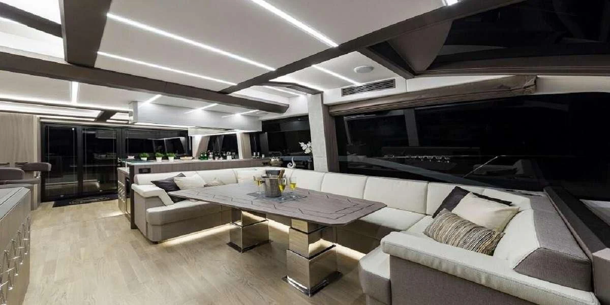 a room with a table and couches aboard TRIPLE T Yacht for Sale