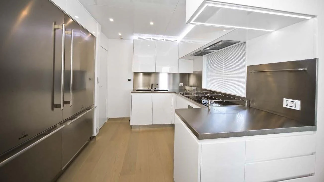 a kitchen with white cabinets aboard OCEAN KING 88 Yacht for Sale