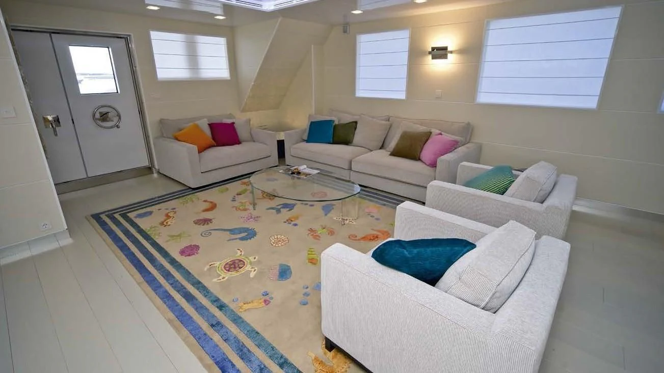 a living room with a rug and couches aboard OCEAN KING 88 Yacht for Sale