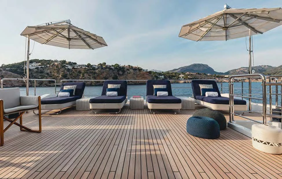 a deck with lounge chairs and umbrellas on it aboard NEW WAVES Yacht for Sale