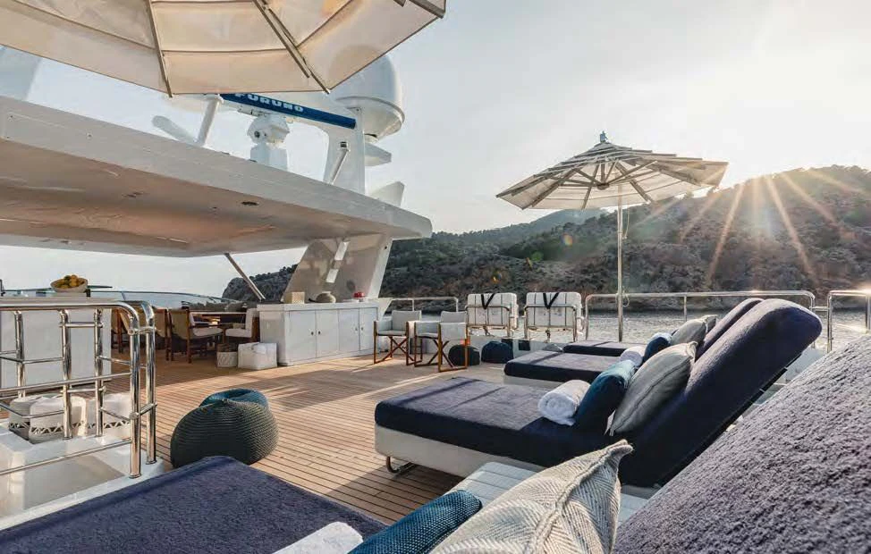 a room with a couch and umbrella aboard NEW WAVES Yacht for Sale