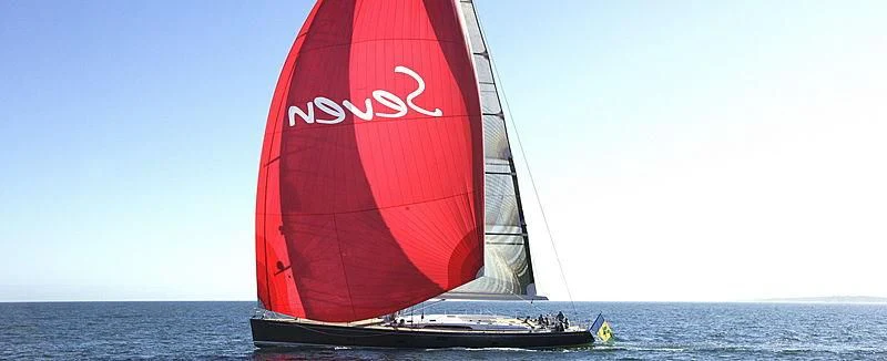 a red sailboat on the water aboard MRS SEVEN Yacht for Sale