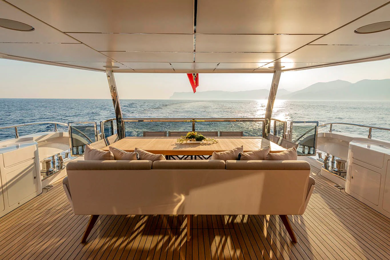 a large white couch on a deck overlooking a body of water aboard ALKHADRA Yacht for Charter