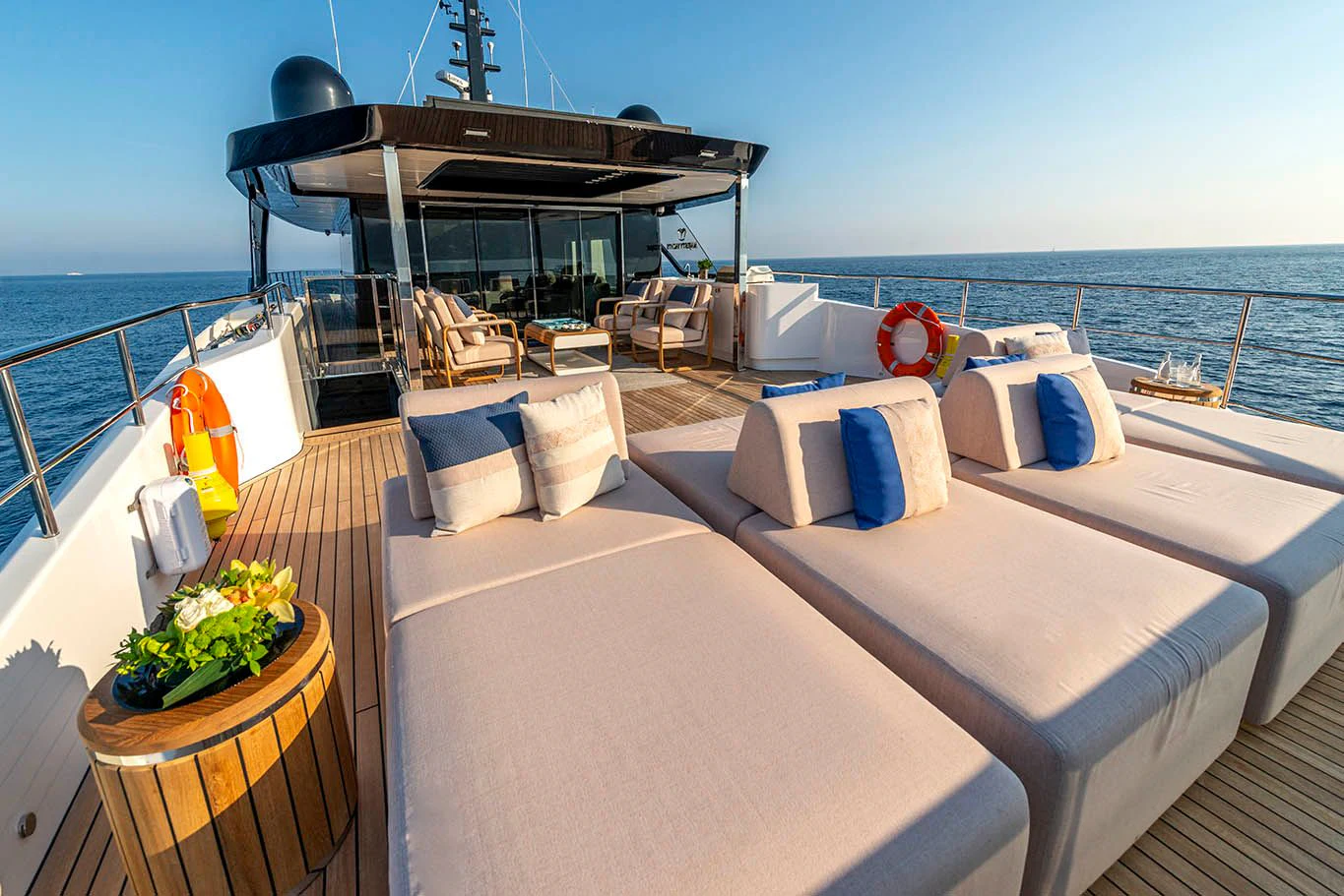 a balcony with a bed and chairs aboard ALKHADRA Yacht for Charter