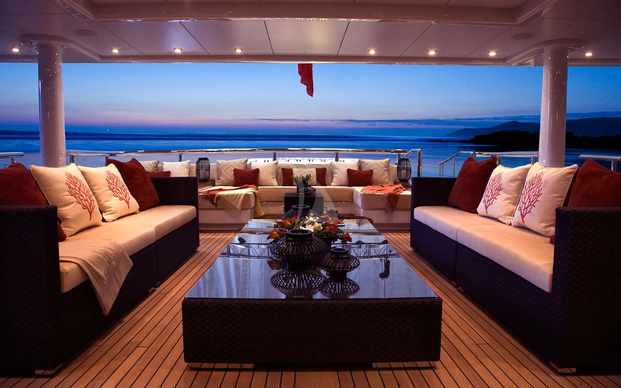a living room with a large sofa and a table with a glass coffee table aboard SEA RHAPSODY Yacht for Sale