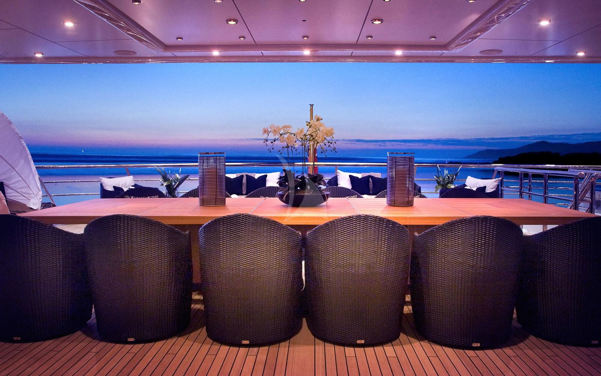 a large room with chairs and a table with a large body of water in the background aboard SEA RHAPSODY Yacht for Sale