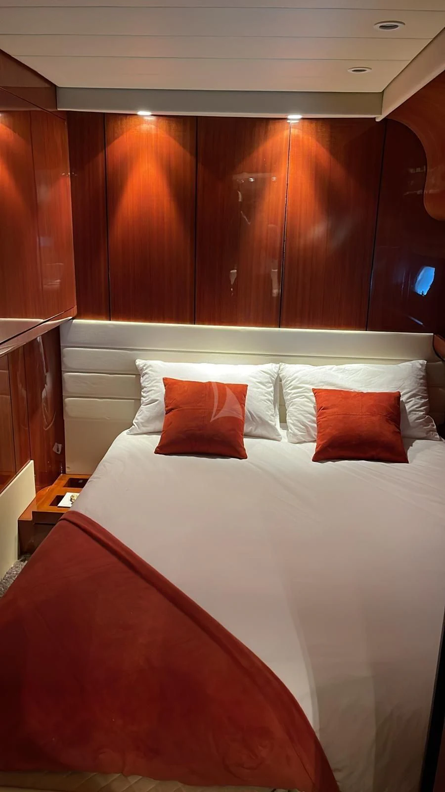 a bed with red pillows aboard NOTORIOUS Yacht for Sale