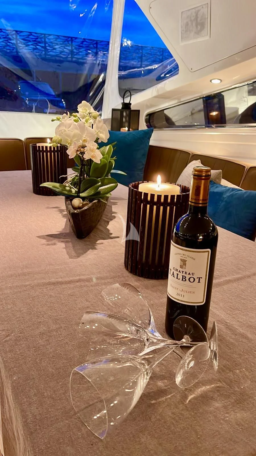 a table with a bottle of wine and a glass of wine aboard NOTORIOUS Yacht for Sale