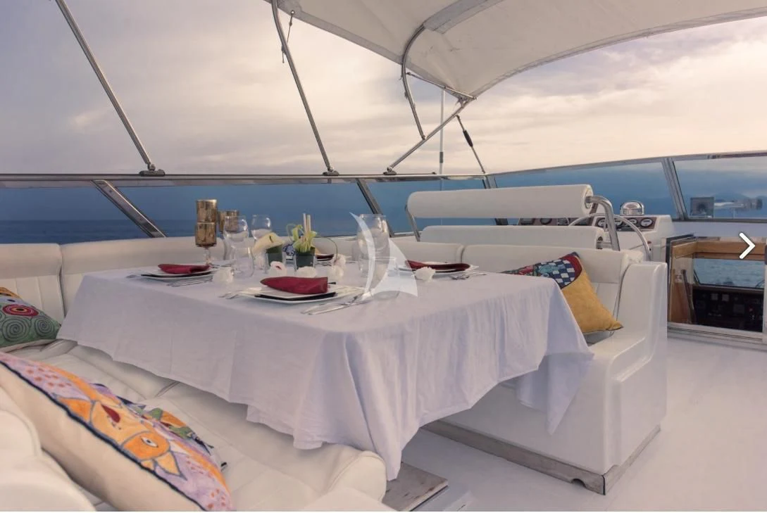 a white table with a white tablecloth and a white couch with a white tablecloth and a aboard MISS CANDY Yacht for Charter