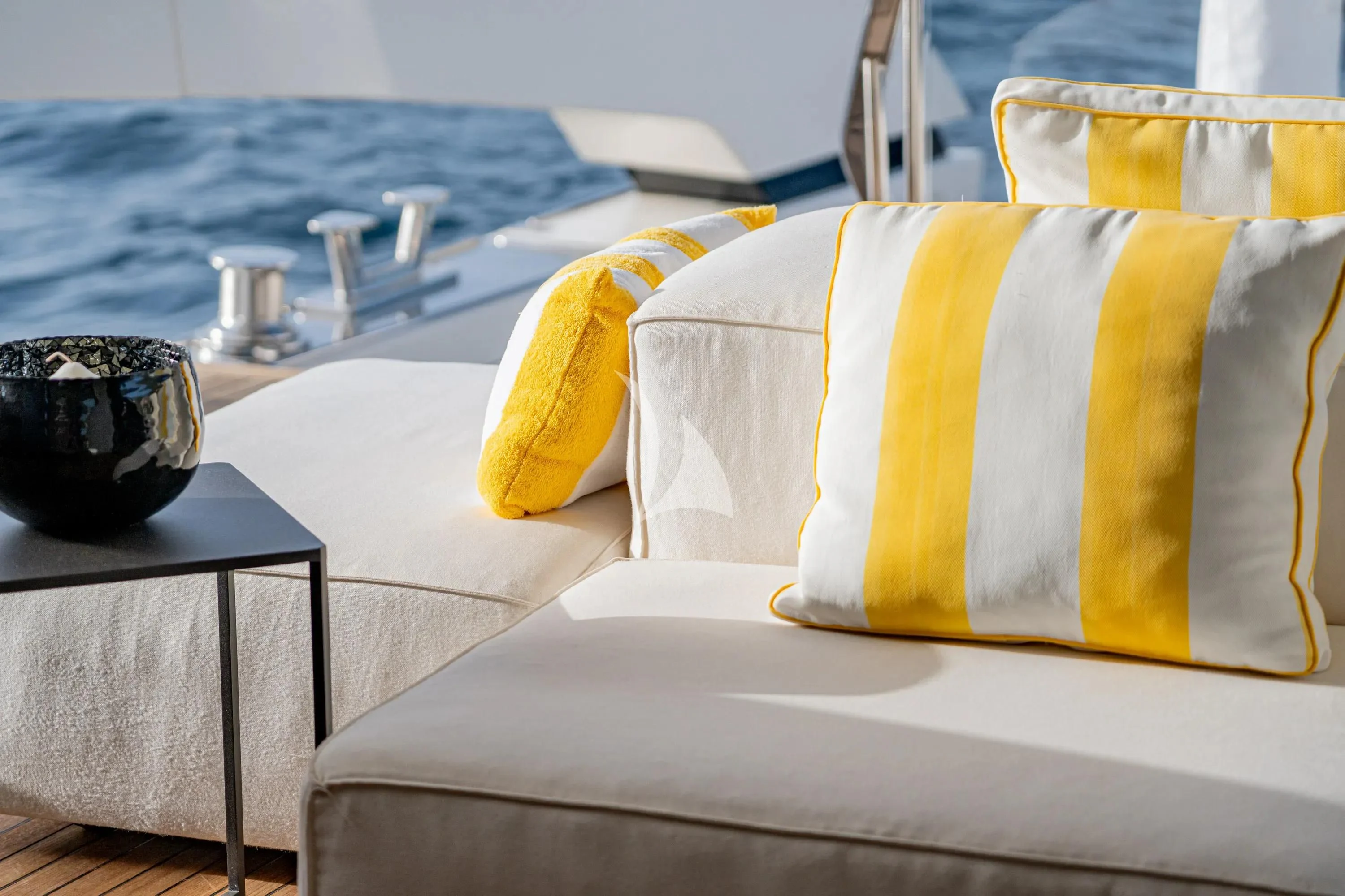 a white couch with a yellow pillow aboard DANIDA Yacht for Charter