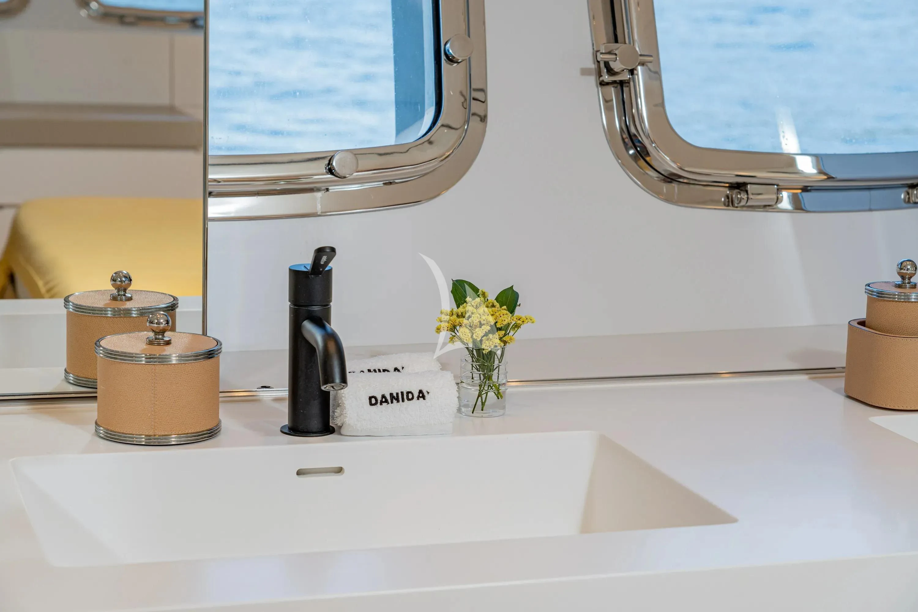 a bathroom sink with a flower vase aboard DANIDA Yacht for Charter