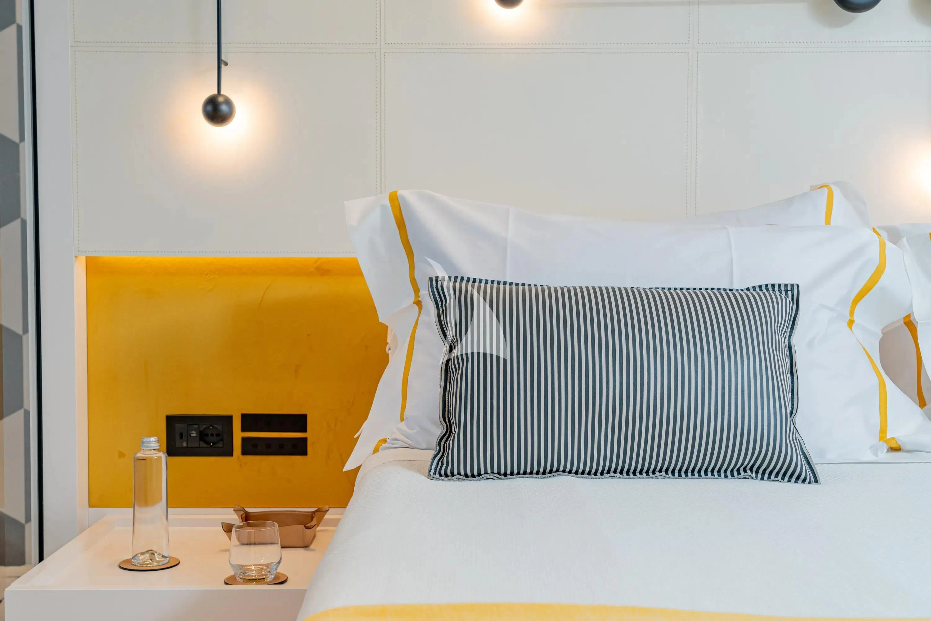 a bed with a white pillow and a white lamp aboard DANIDA Yacht for Charter