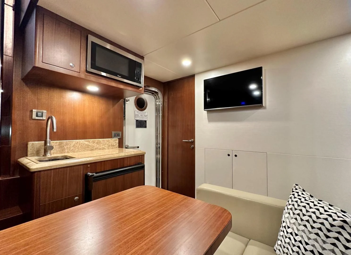 a kitchen with a table and tv aboard CRUMDALE Yacht for Sale