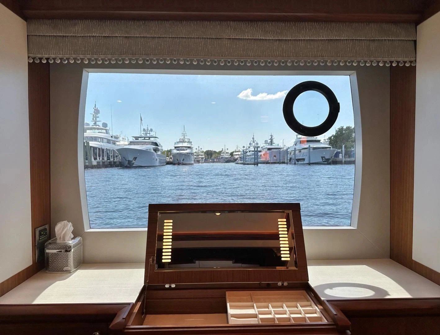 a laptop on a table in front of a window overlooking a body of water aboard CRUMDALE Yacht for Sale