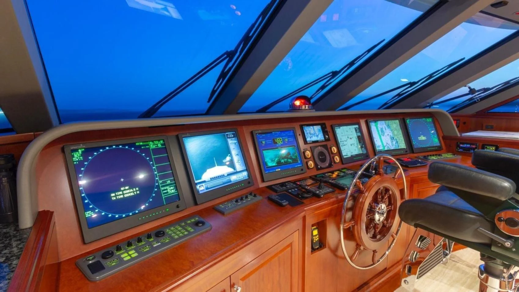 a computer desk with several monitors aboard LEGACY Yacht for Sale