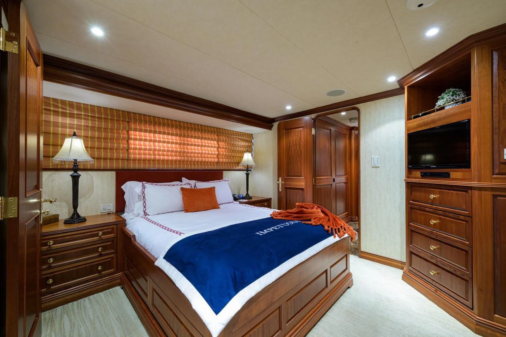 a bedroom with a bed and a dresser aboard LEGACY Yacht for Sale
