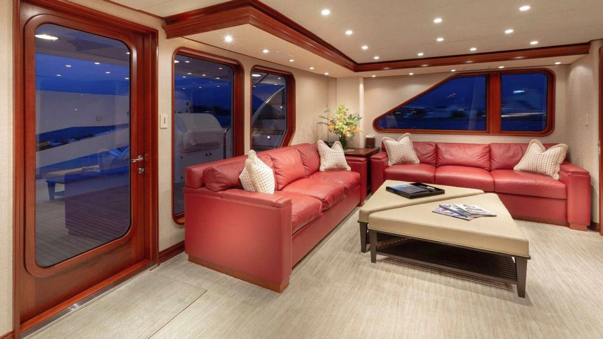 a living room with a red couch aboard LEGACY Yacht for Sale