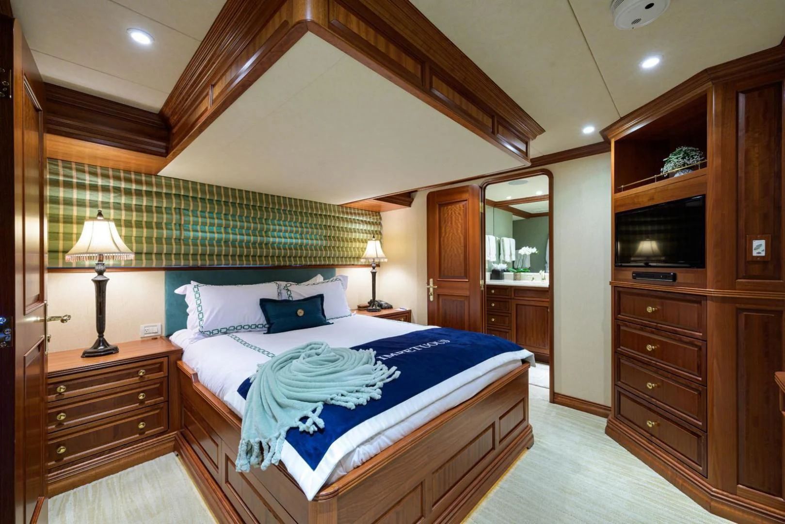 a bedroom with a bed and a television aboard LEGACY Yacht for Sale