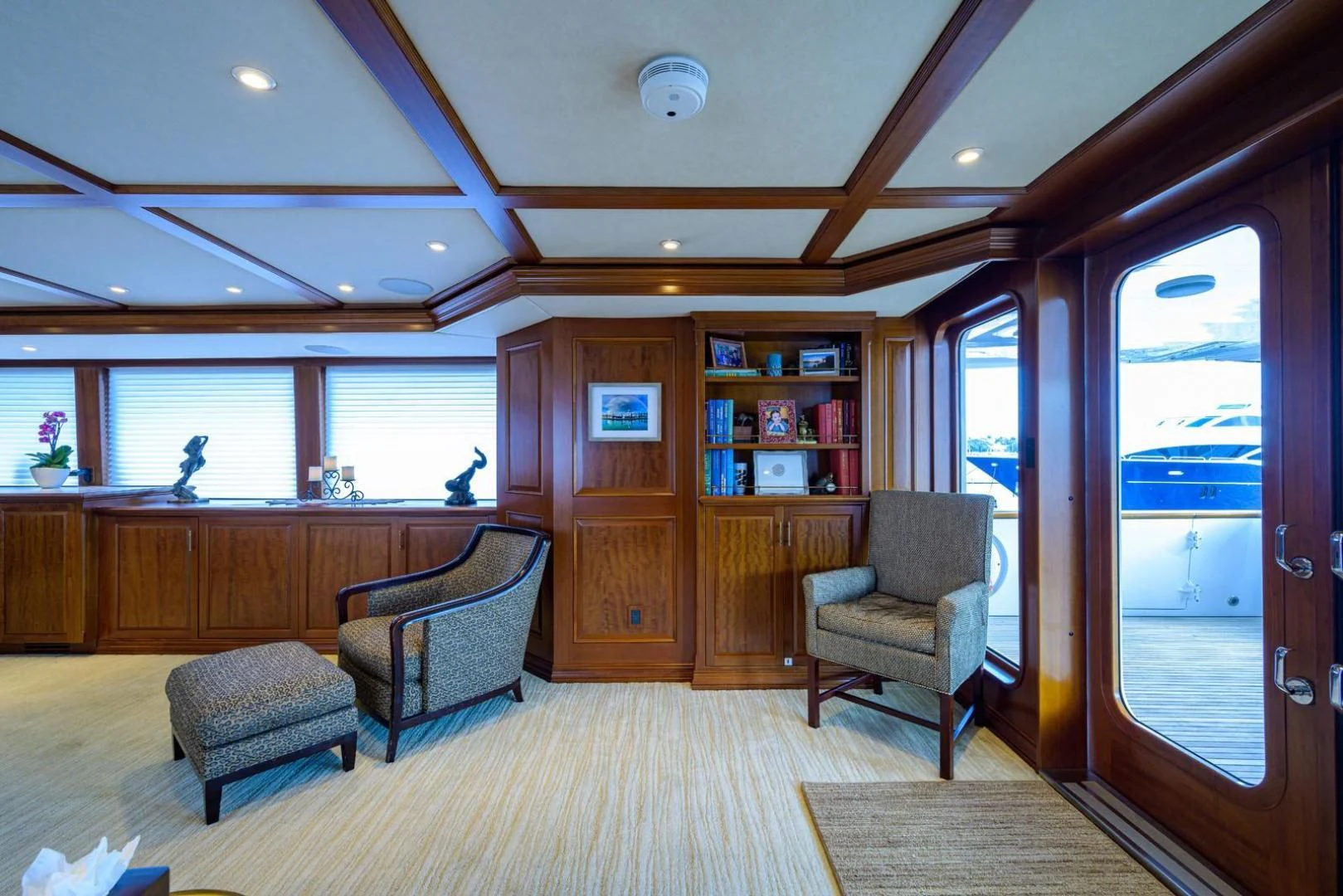 a room with a couch and a chair and a bookcase aboard LEGACY Yacht for Sale