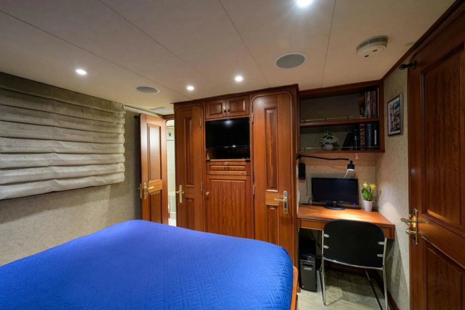a bedroom with a desk and a bed aboard LEGACY Yacht for Sale