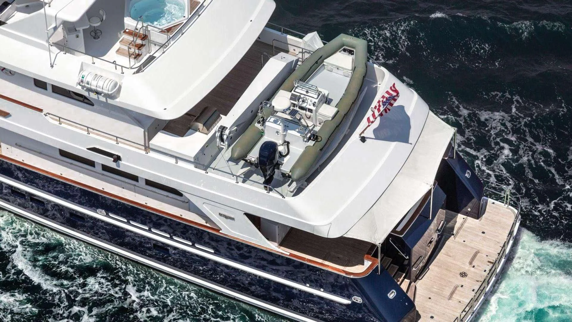 a large white boat with a person standing on it aboard LEGACY Yacht for Sale