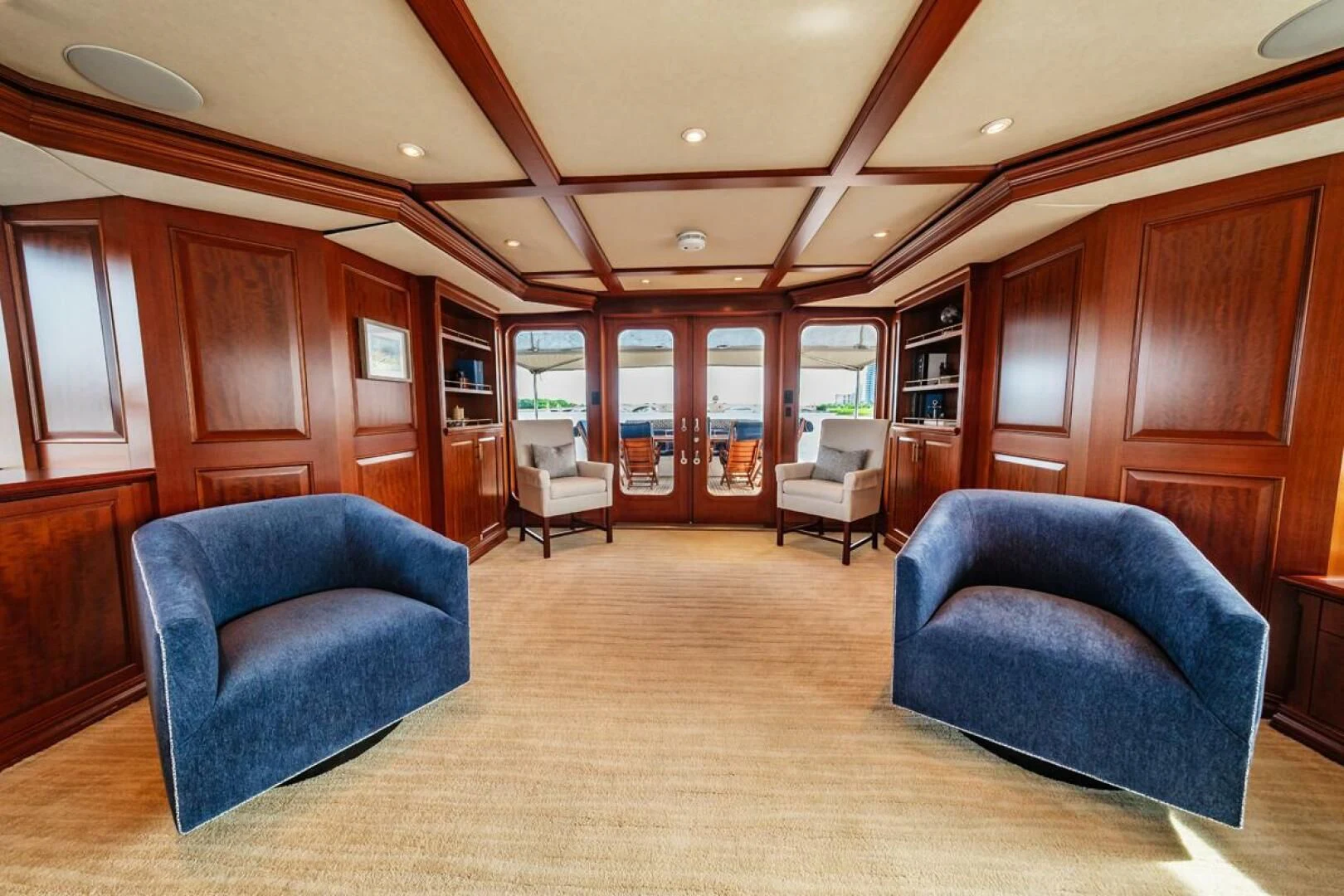 a living room with a blue couch aboard LEGACY Yacht for Sale