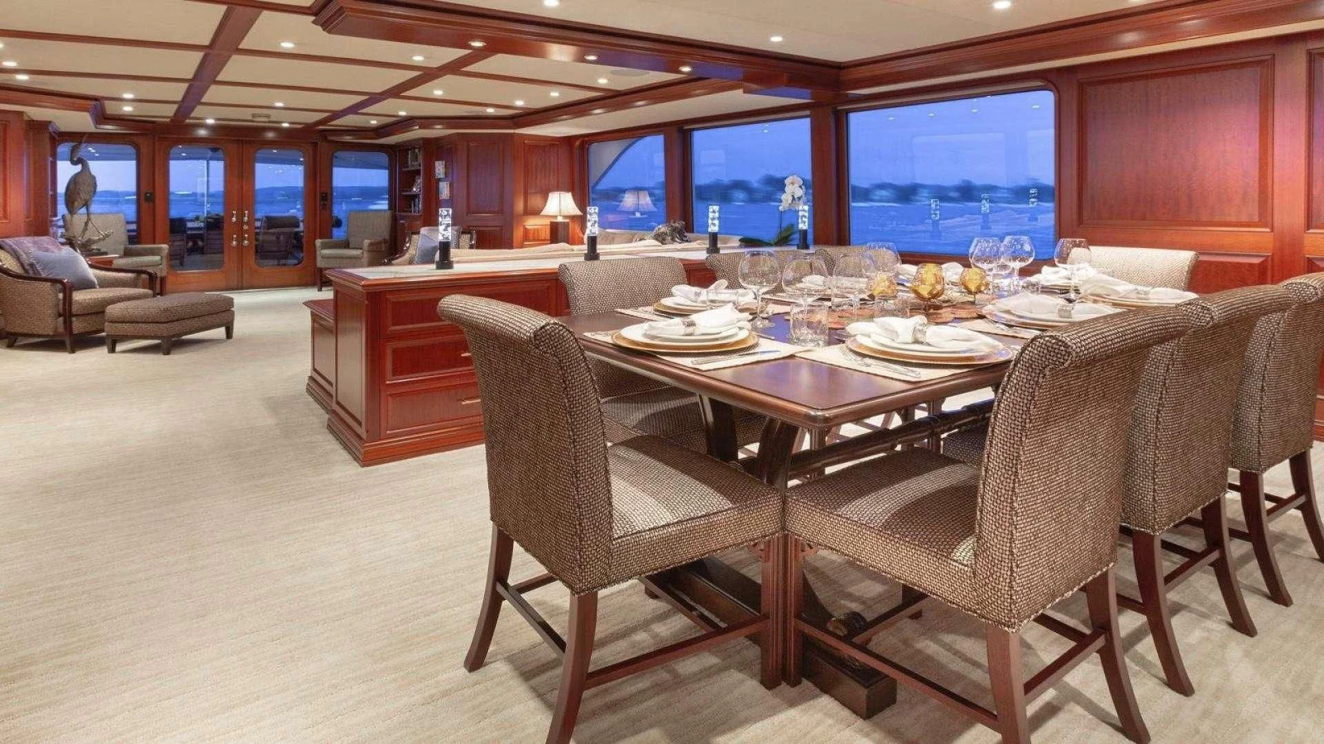 a large room with a table and chairs aboard LEGACY Yacht for Sale