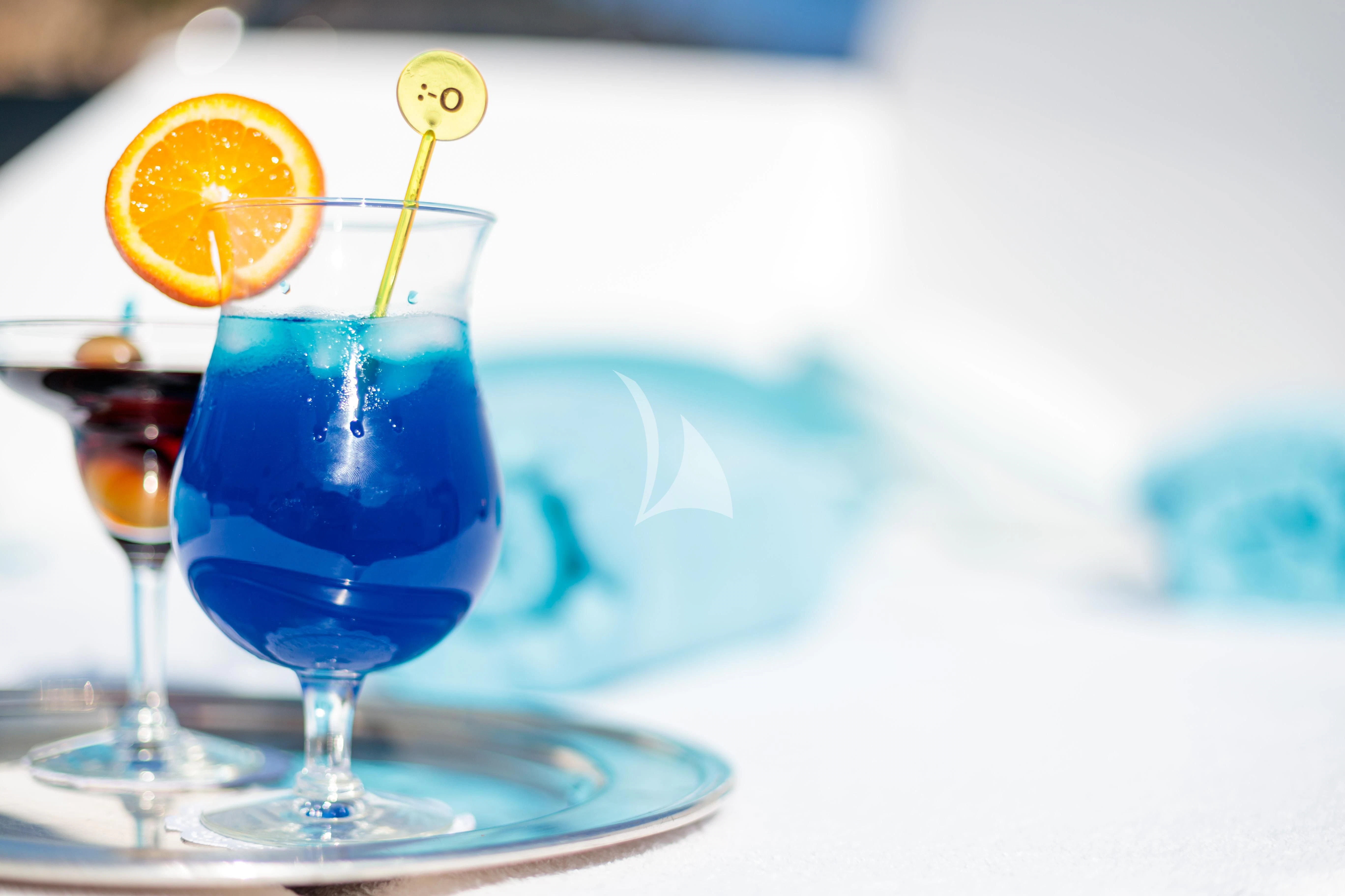 a glass of liquid with a lemon on a plate aboard HEMILEA Yacht for Charter