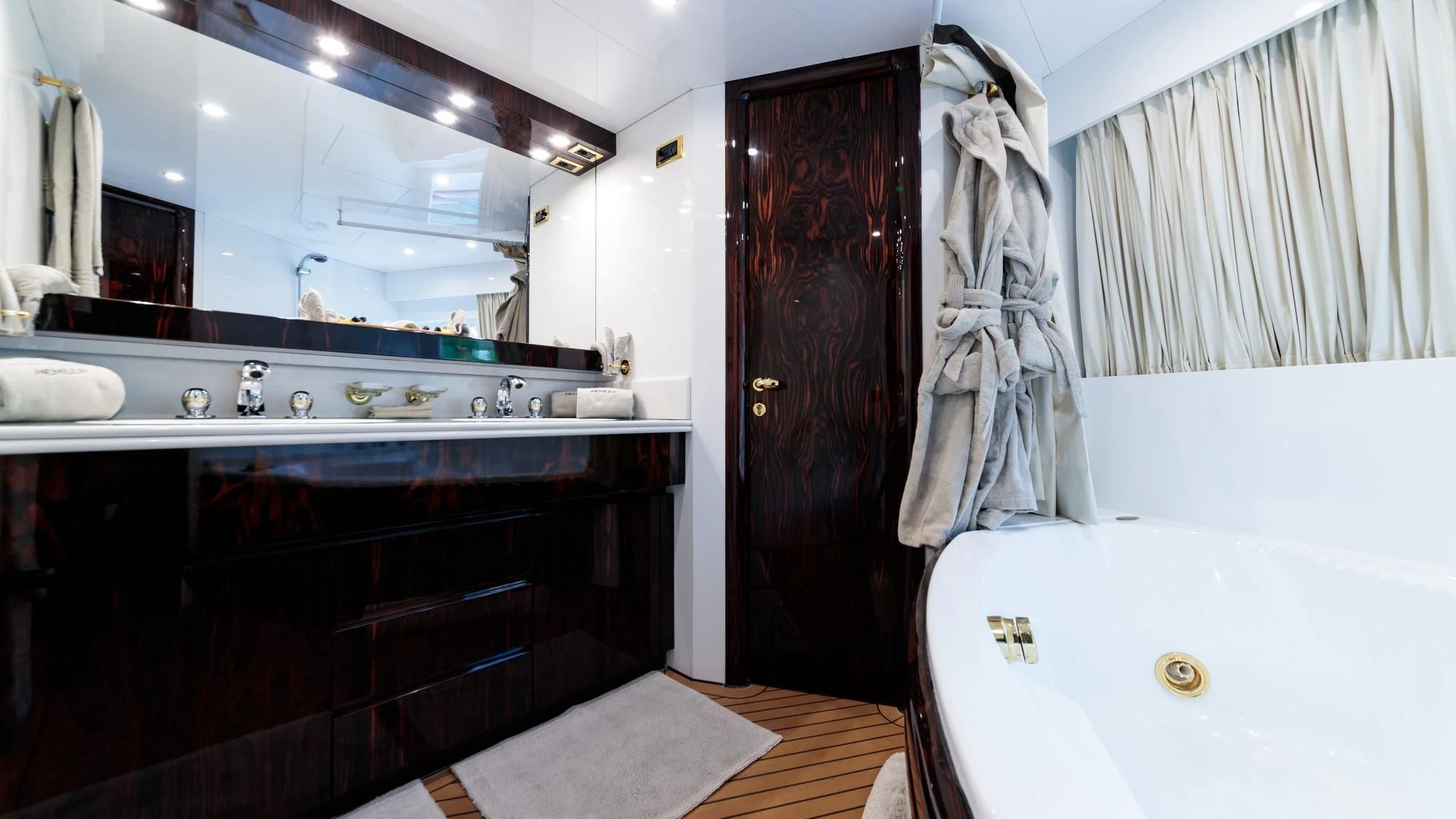 a bathroom with a bathtub sink and a mirror aboard HEMILEA Yacht for Charter