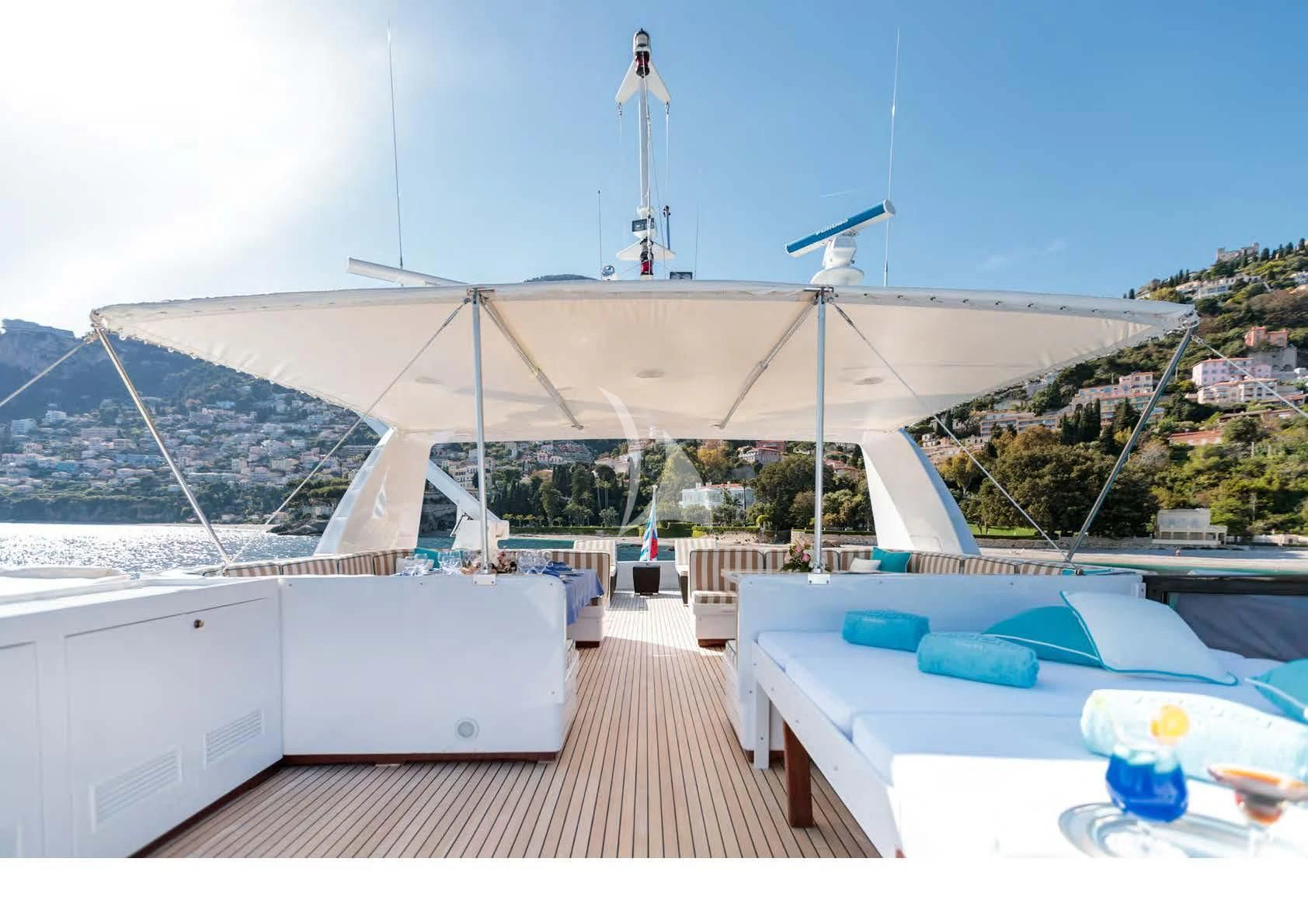 a deck with a pool and a building with a large white roof aboard HEMILEA Yacht for Charter