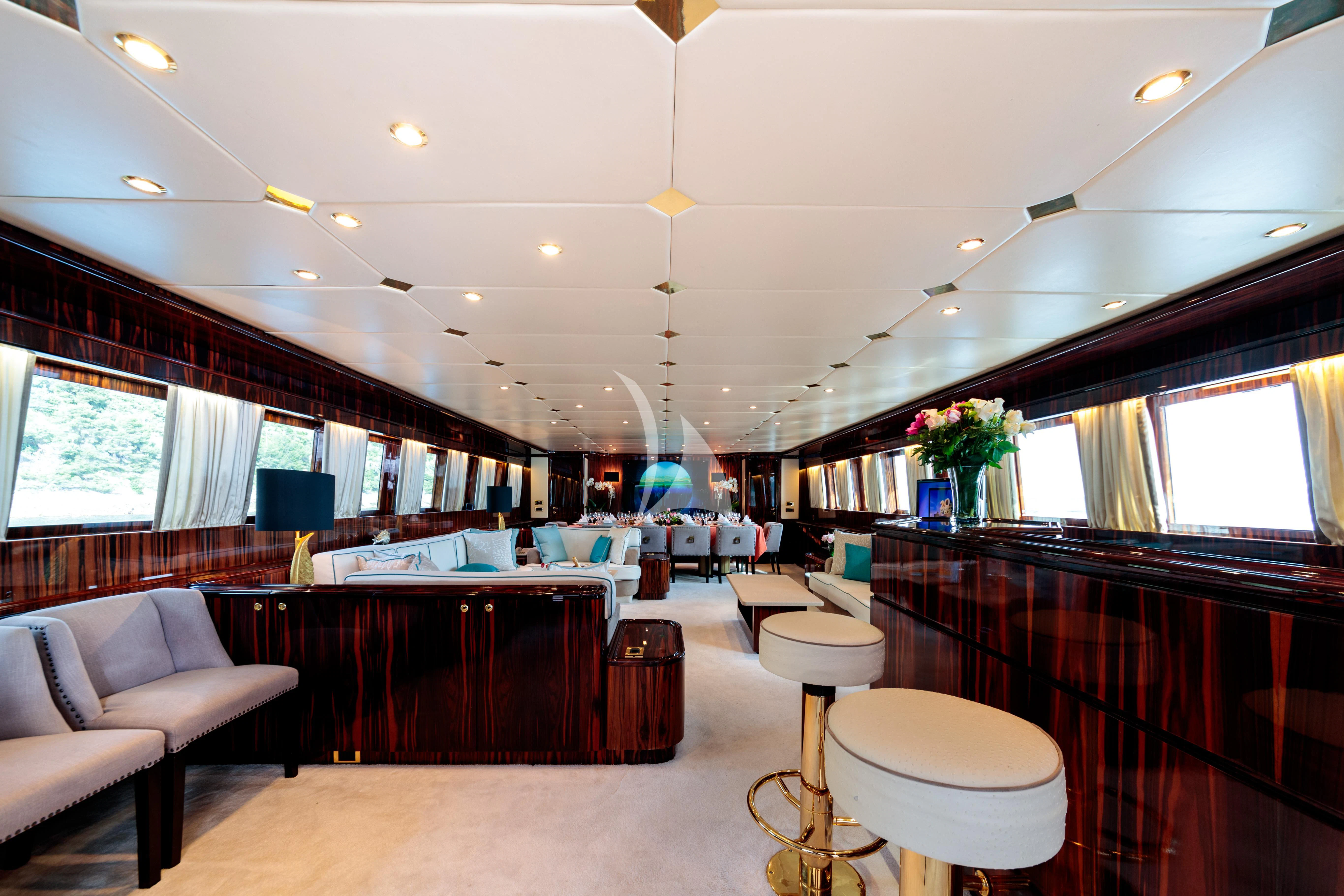 a large room with a bar and chairs aboard HEMILEA Yacht for Charter