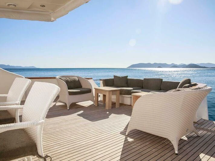 a lounge area with chairs and a body of water in the background aboard BLANCO Yacht for Sale