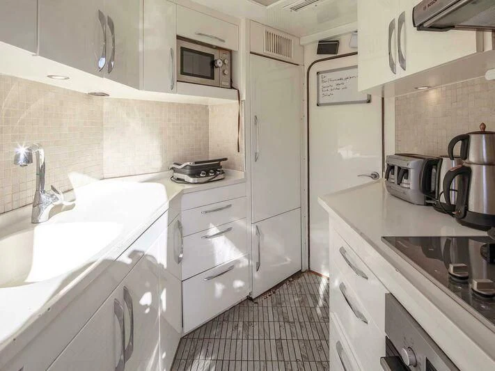 a kitchen with white cabinets aboard BLANCO Yacht for Sale