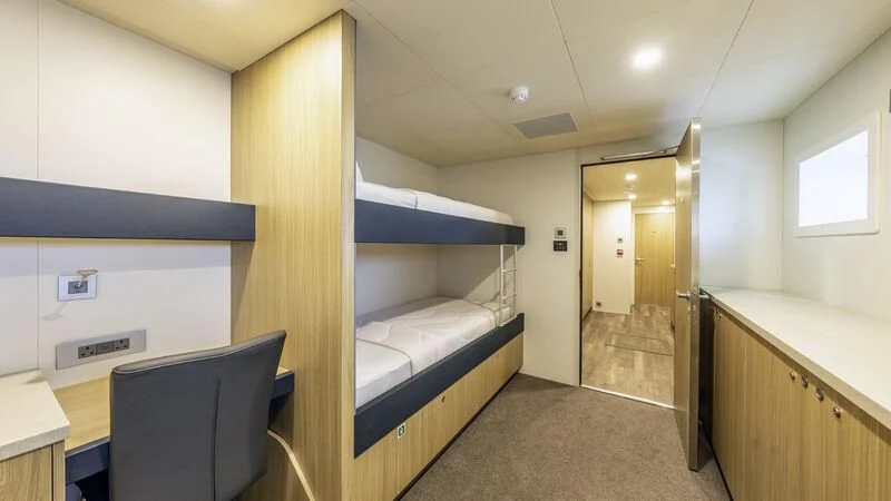 a room with a bed and desk aboard CHARLEY 2 Yacht for Sale