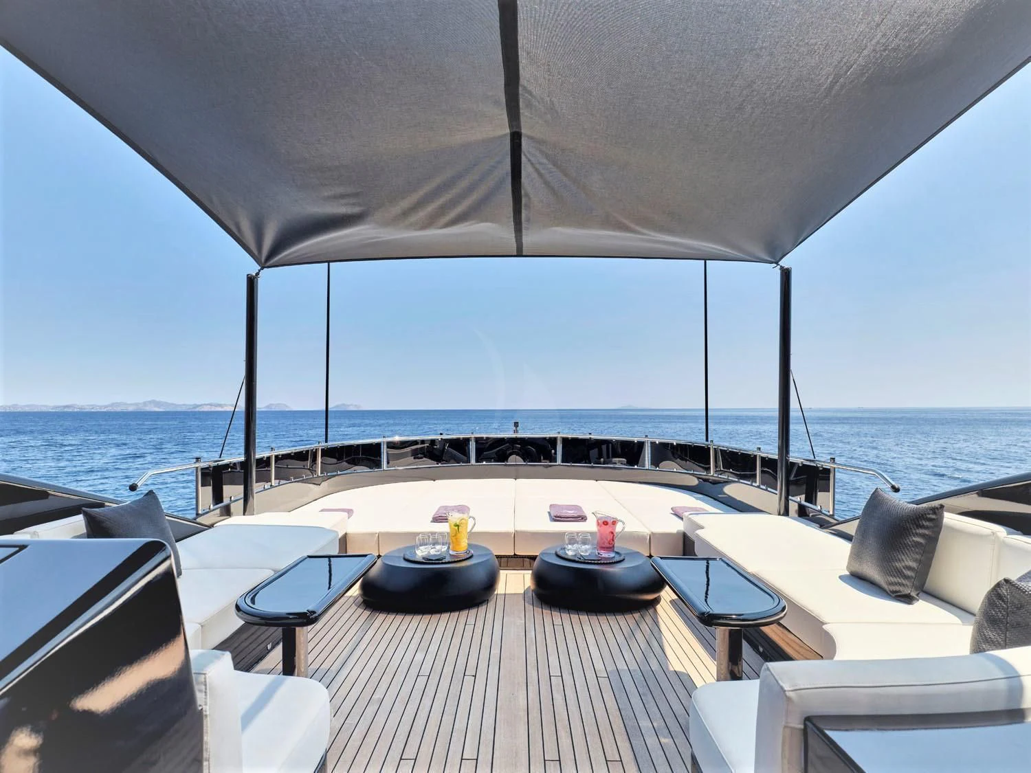 a large white umbrella over a table and chairs on a deck overlooking the ocean aboard ABILITY Yacht for Sale