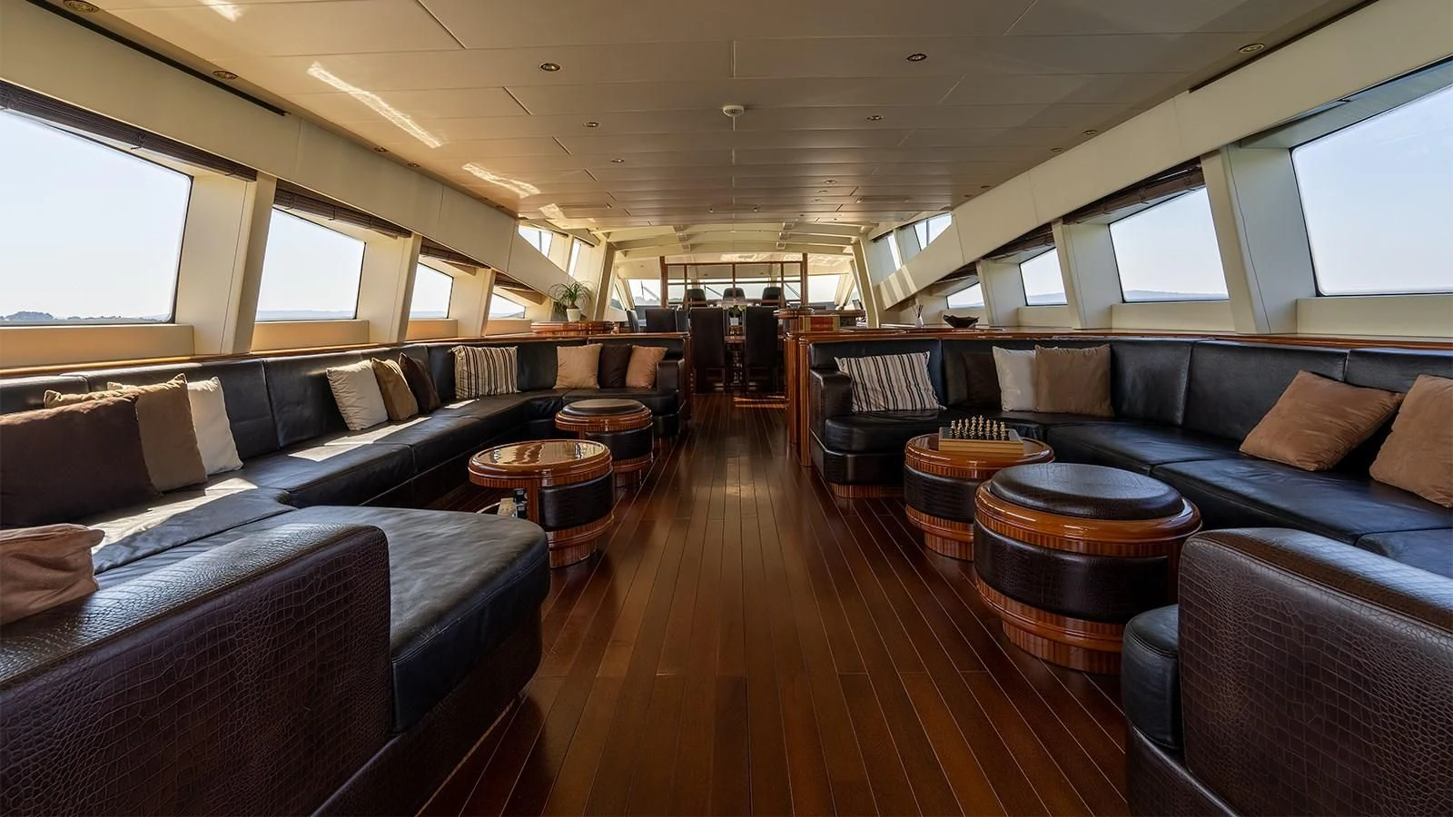 a large living room with leather couches and a wood table aboard ABILITY Yacht for Sale