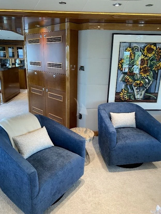 a room with a blue couch and a wood cabinet aboard SEANASH Yacht for Sale
