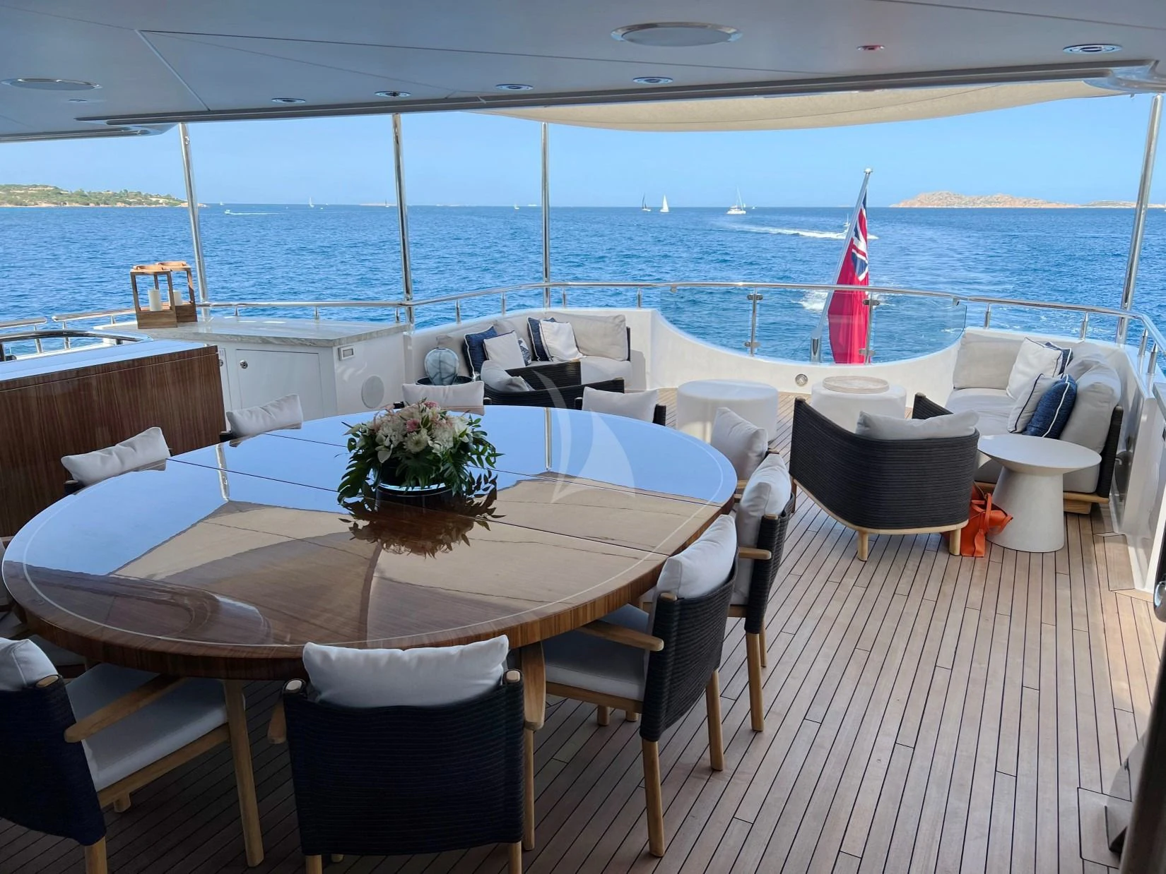 a table and chairs on a deck overlooking a body of water aboard SEANASH Yacht for Sale