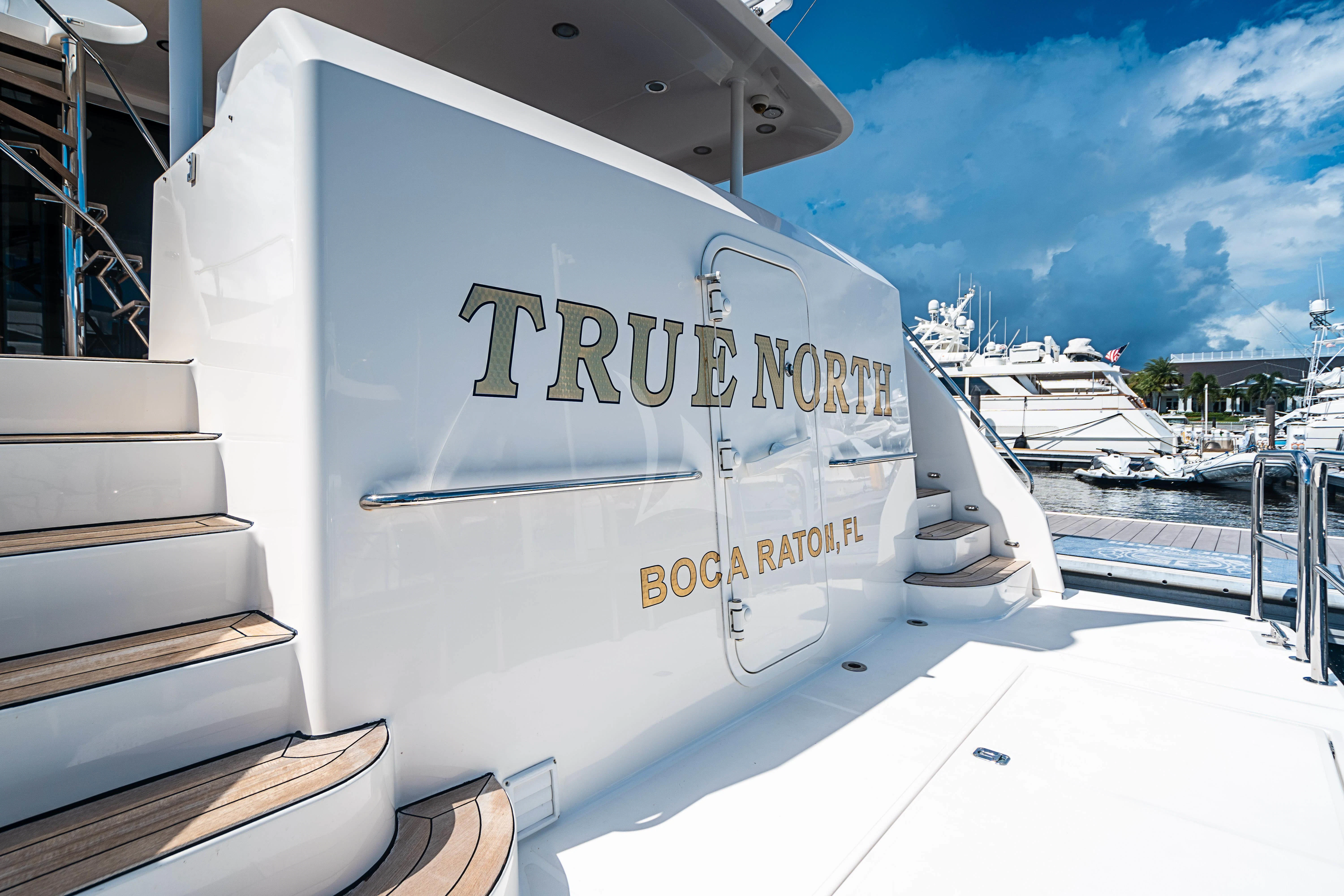a white boat on a dock aboard BOOGIE BABE IV Yacht for Sale