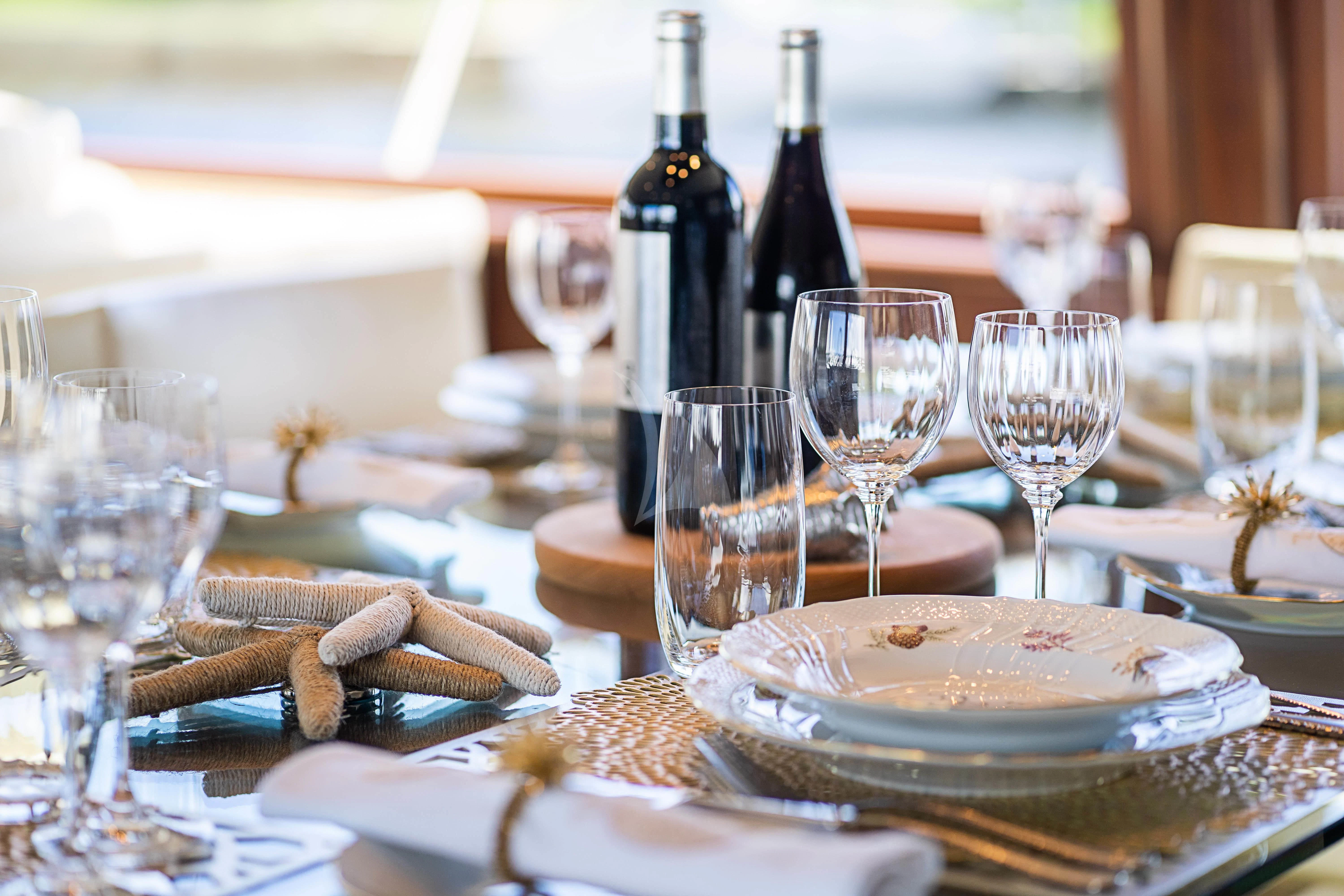 a table with wine glasses and plates aboard BOOGIE BABE IV Yacht for Sale
